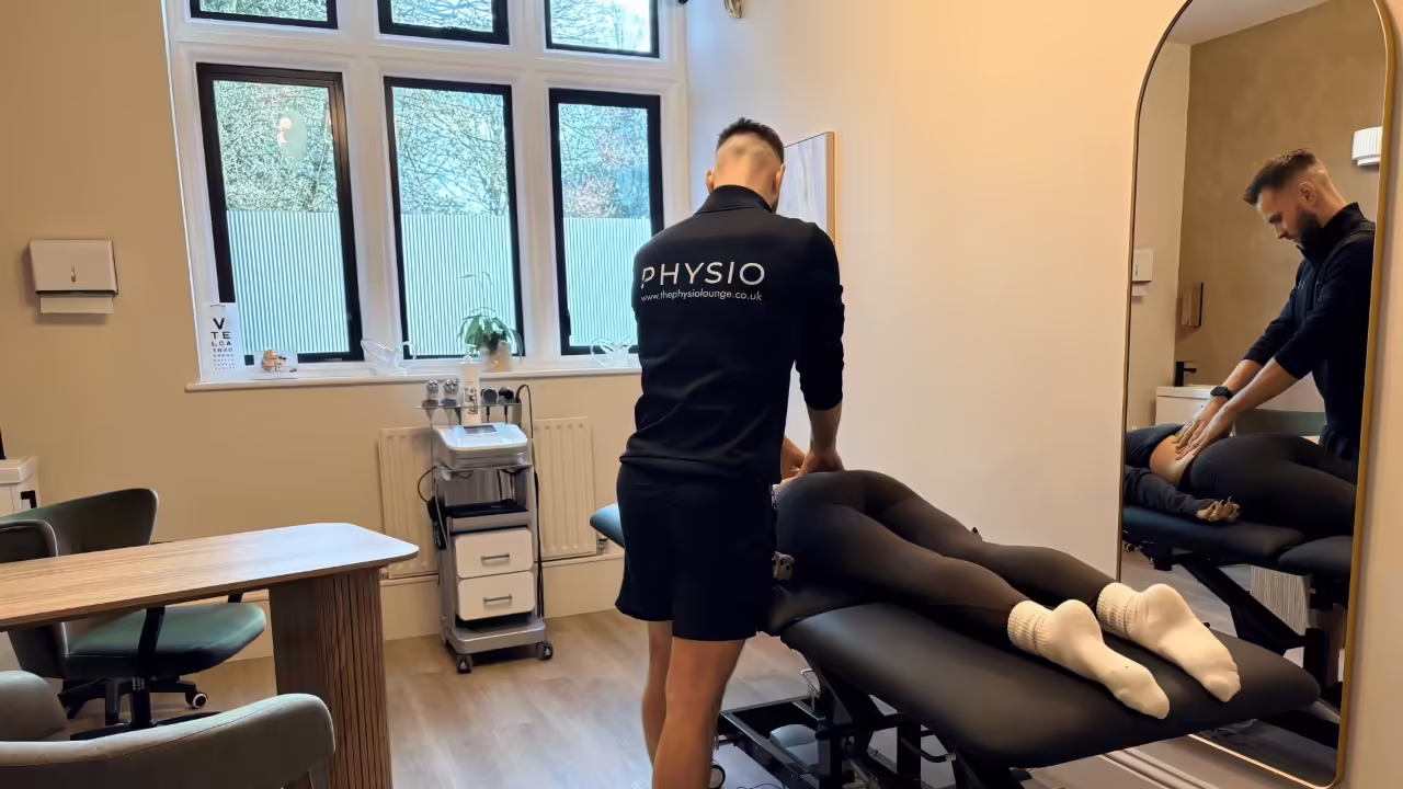 Sports massage treatment being performed on an athlete in a clinical treatment room